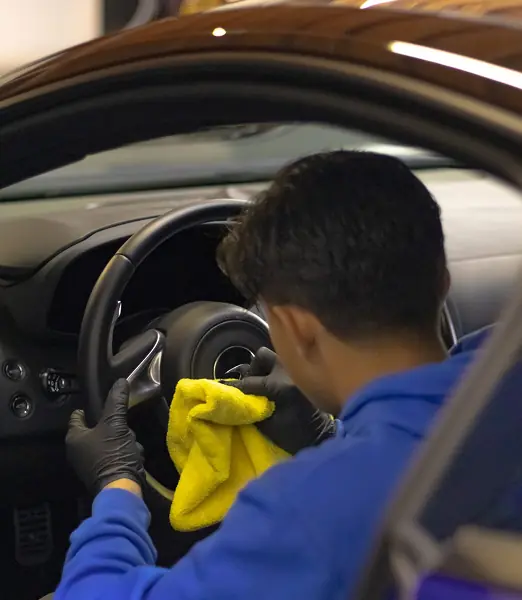 ONDMOVE technician detailing a steering wheel and dashboard